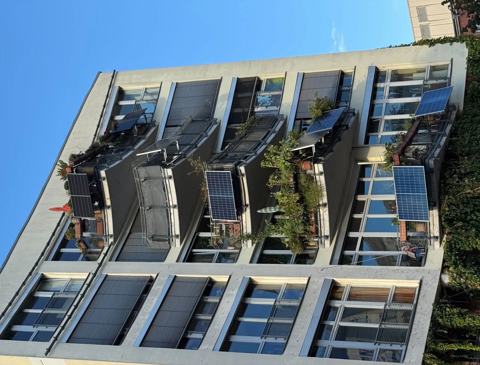 Plug in solar panels hung on the balconies of an apartment building