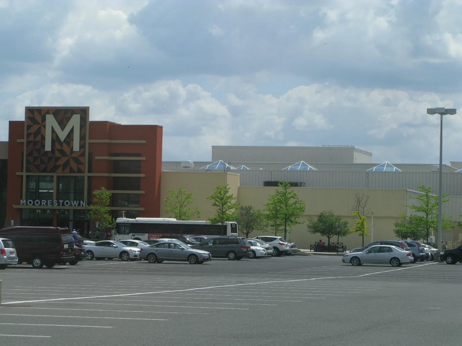 The Moorestown Mall entrance, a brick tower with a large M and the word Moorestown, beside the mall's parking lot
