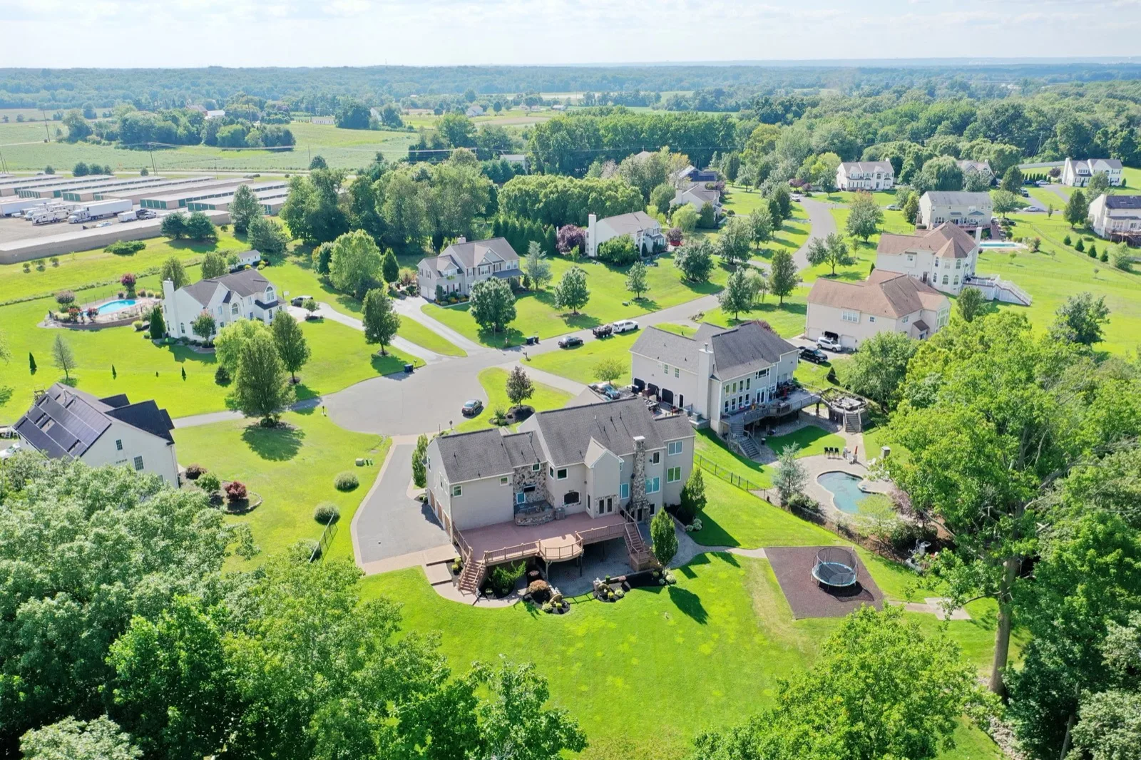 Aerial view of an established South Jersey neighborhood of large-lot homes on a summer afternoon