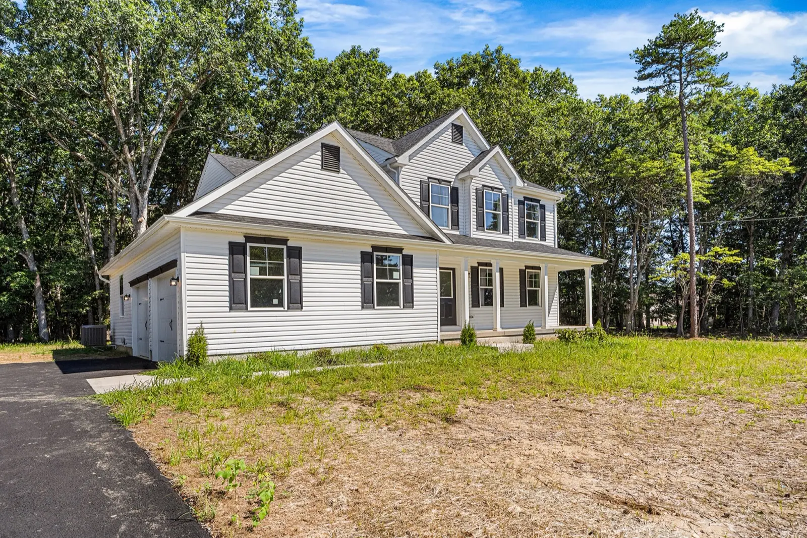 A newly built two story home with a front porch on a freshly seeded lot in Williamstown